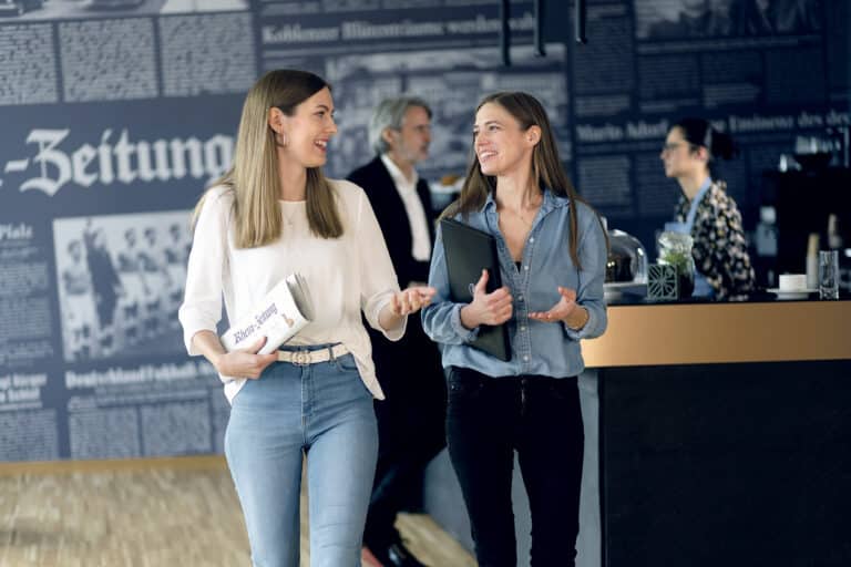 Zwei Frauen schauen sich an und unterhalten sich in einem Bistro